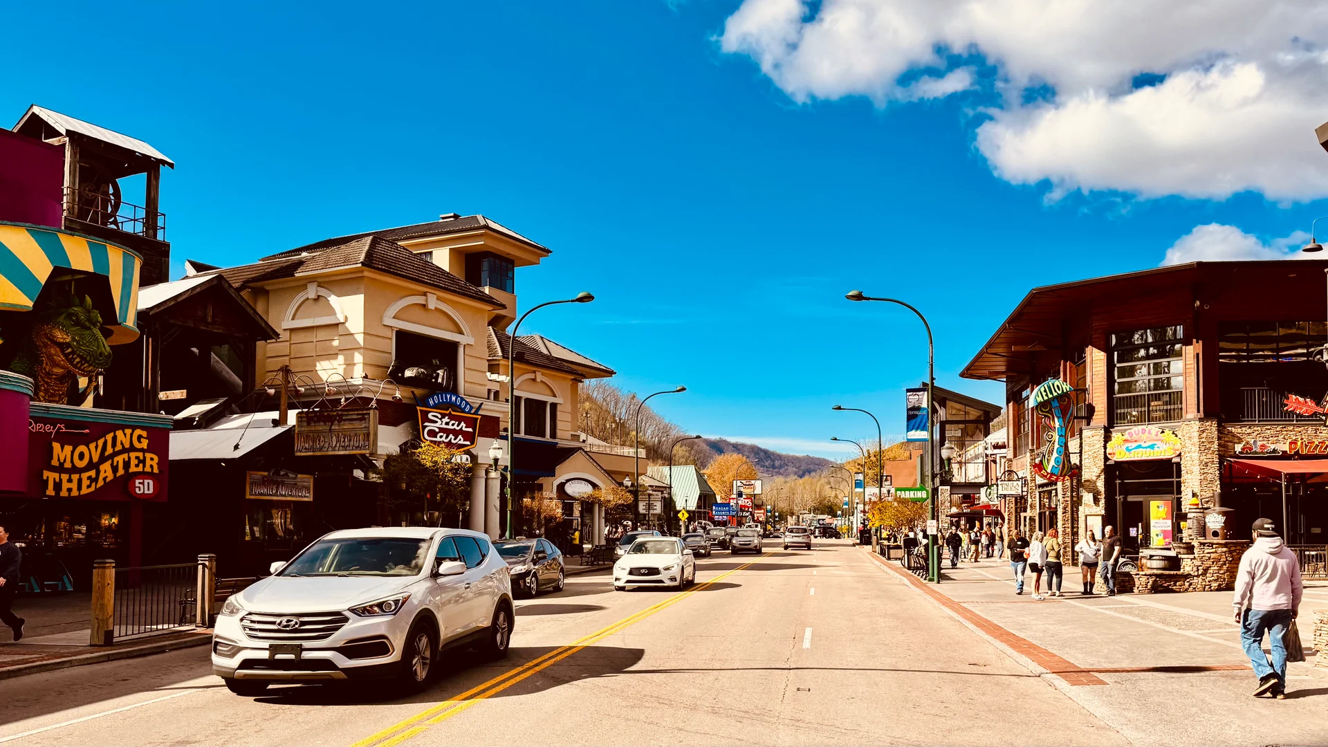 Downtown Gatlinburg's Parkway lined with shops and attractions, with the Smoky Mountains rising in the background